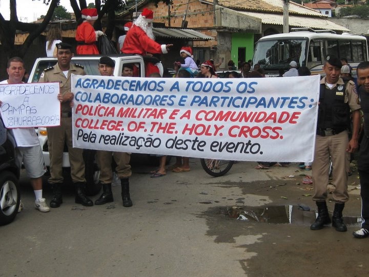 Police officers and volunteers in Belo Horizonte holding a banner thanking the College of the Holy Cross community