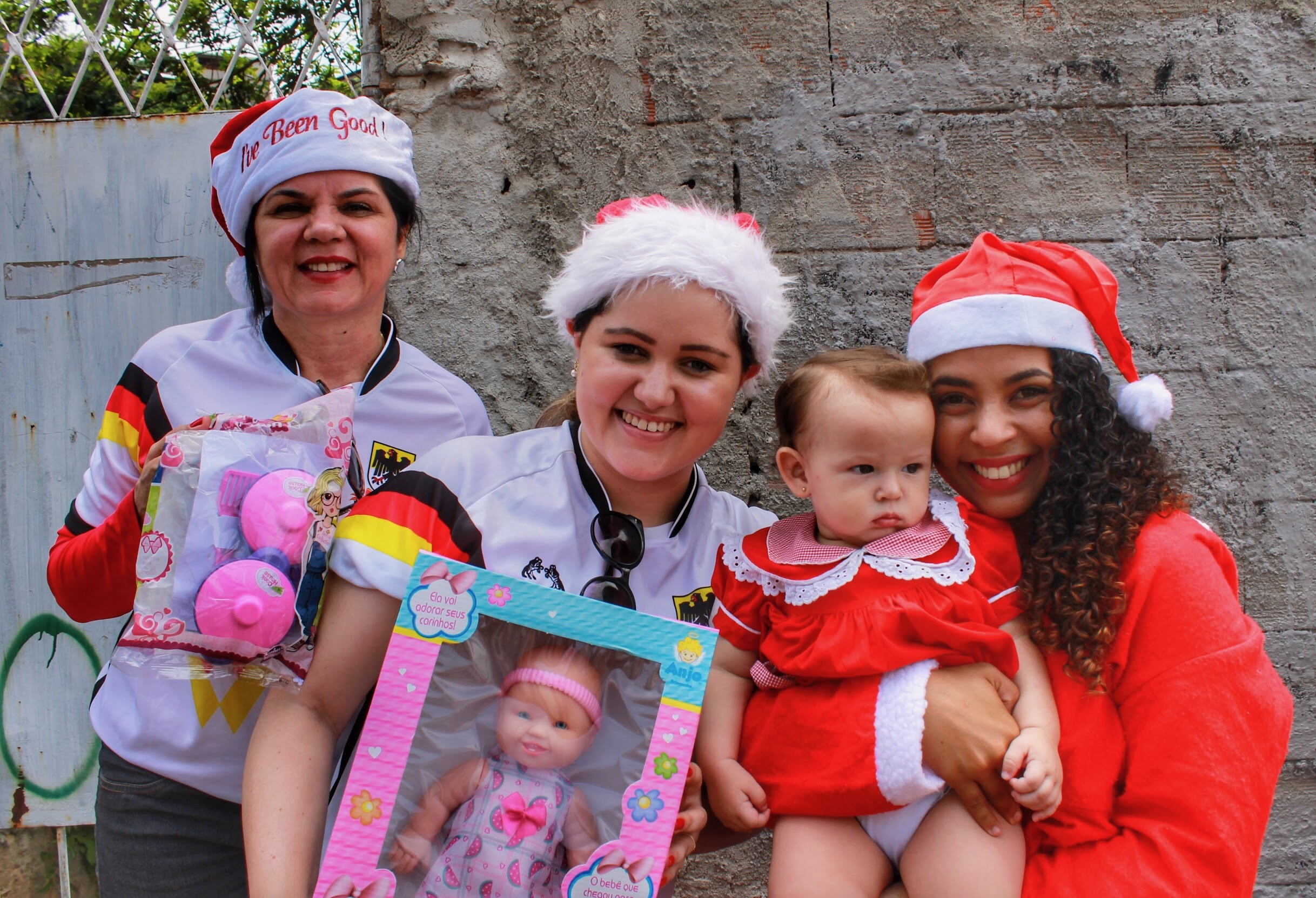 Volunteers in Santa hats holding babies during the Christmas delivery