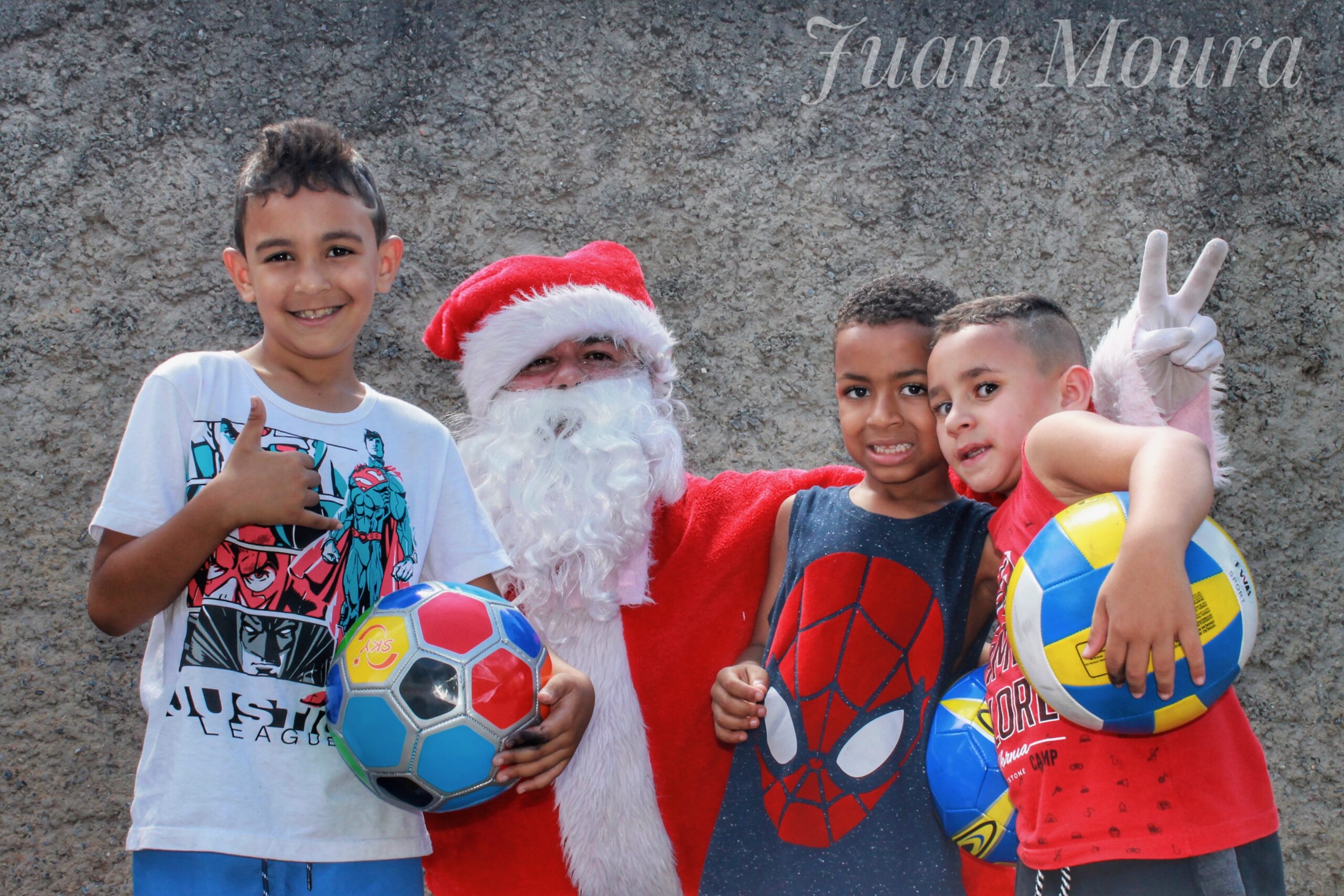 Santa with three boys holding new soccer balls
