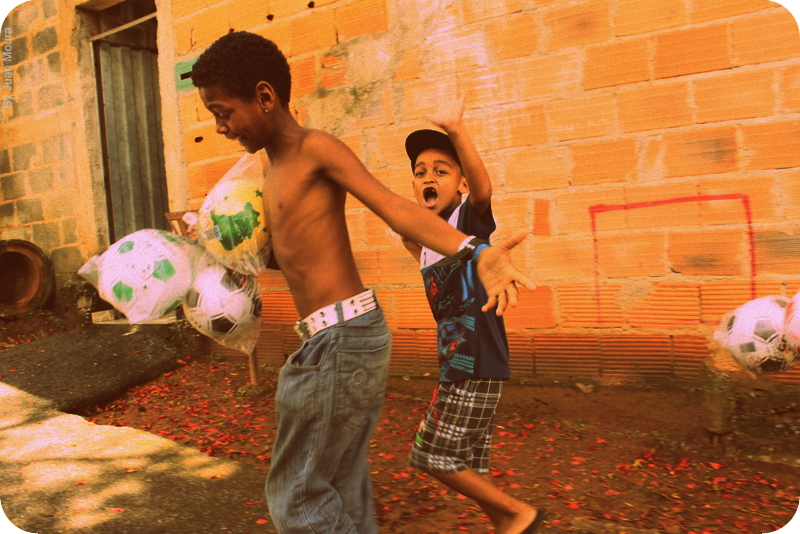 Two boys running with a bag of new soccer balls, Belo Horizonte
