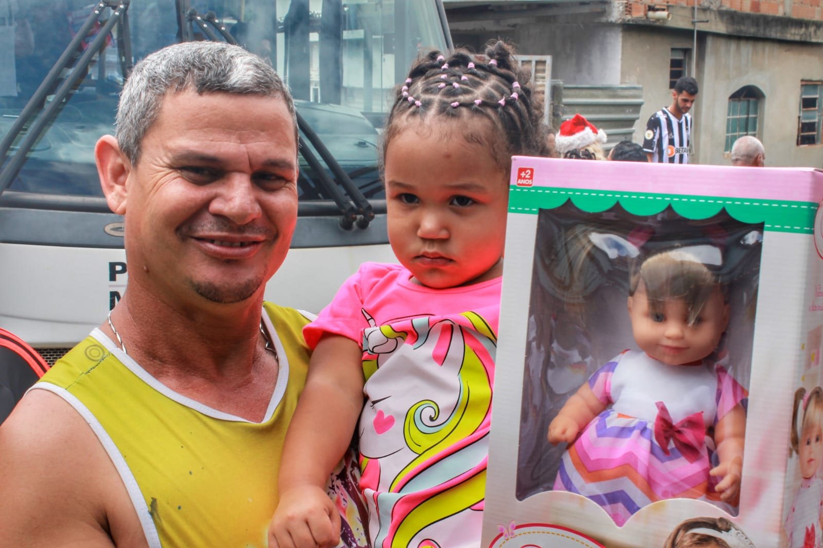 A father holding his daughter and her new doll, Christmas 2022