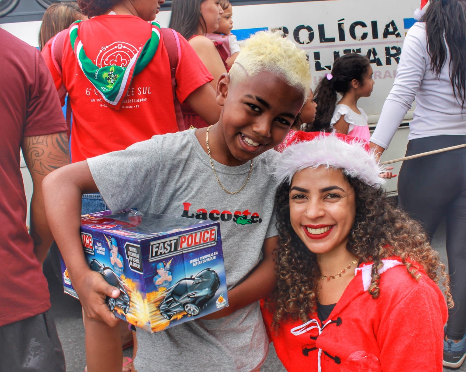 A boy receiving a toy car from a volunteer, 2022