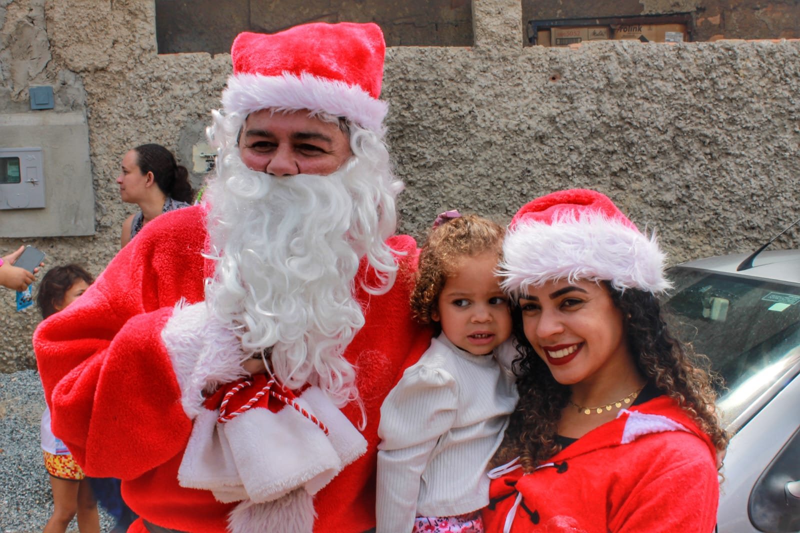 Santa and volunteers with a toddler, 2022